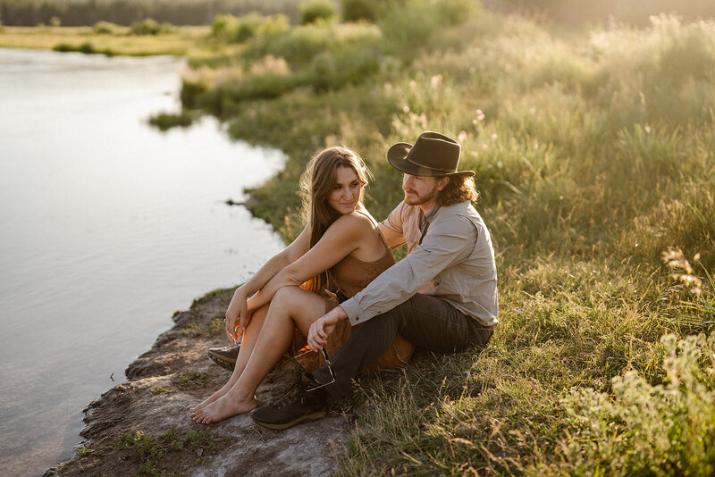 bend oregon engagement photo couple sitting by deschutes river