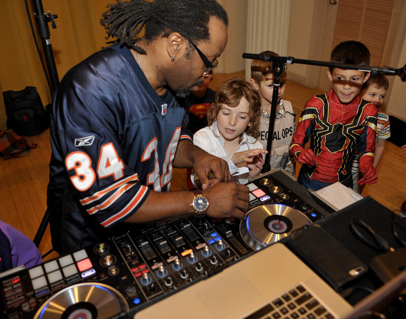 Chicago DJ performing at private kids party in sports jersey with interactive music setup