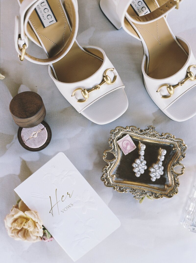 flatlay of wedding shoes and earrings