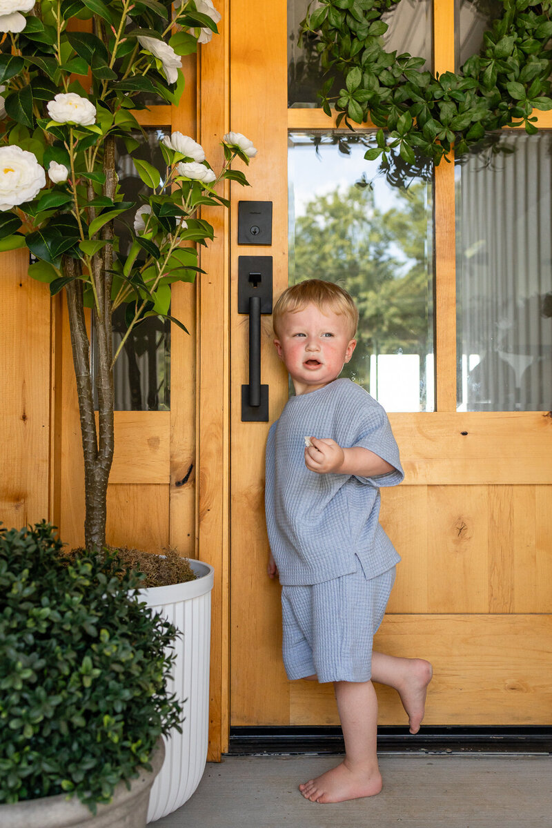 Little boy standing at his front door on his front porch taken by Jennifer Mosier Photography.