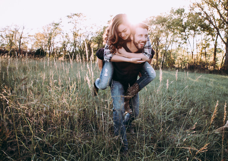 Couple laughing together in a wildflower meadow, capturing candid joy with an Oregon Coast Elopement and Wedding Photographer.