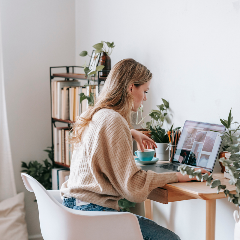 Woman sitting at a desk with a laptop and coffee, starting her day with intention and curiosity