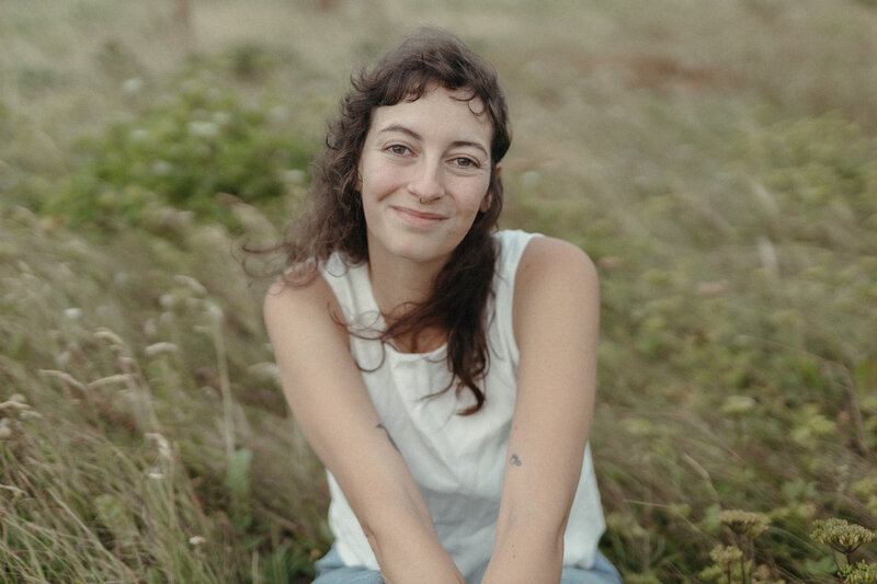 Heather smiles serenely in a meadow of tall grass