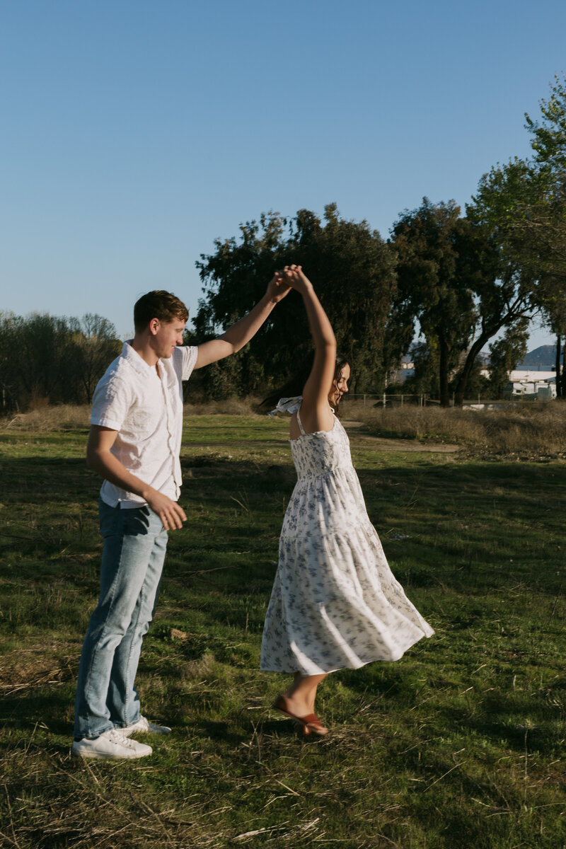 David twirling Elizabeth around in a field.