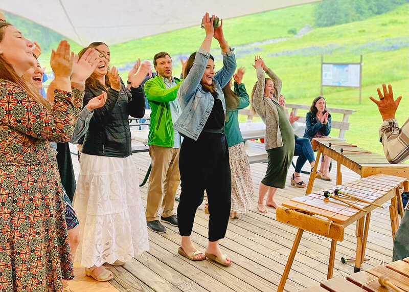 A group celebrates, hands in the air as a band finishes playing on the deck at Ragged Mountain in Camden, Maine.