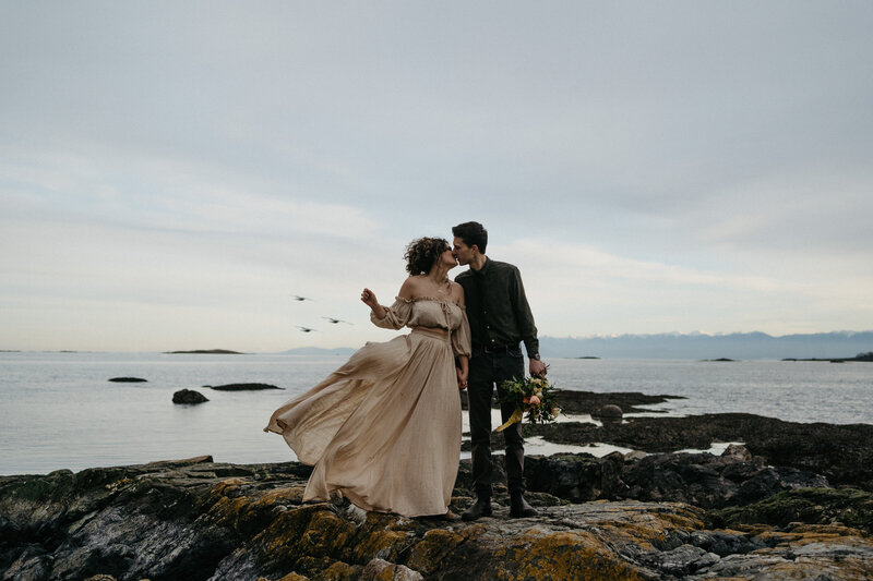 couple kissing on windy shoreline