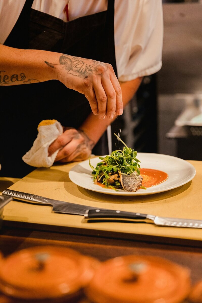Mesquite Fork's chef artfully prepares a signature Texas-inspired dish, blending local ingredients with refined techniques for a memorable dining experience.
