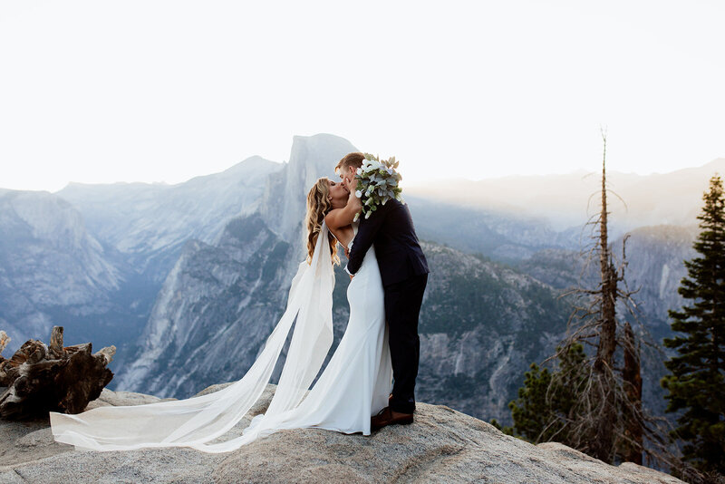 bride and groom kissing at their ceremony at glacier point yosemite at sunrise for their elopement