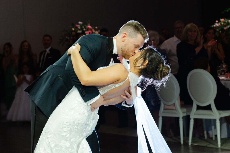 a groom dips his bride during their first dance during their Chateau Le Parc wedding reception.  Captured by Ottawa wedding photographer JEMMAN Photography