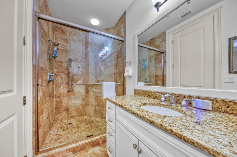 bathroom with granite countertop and walk in shower