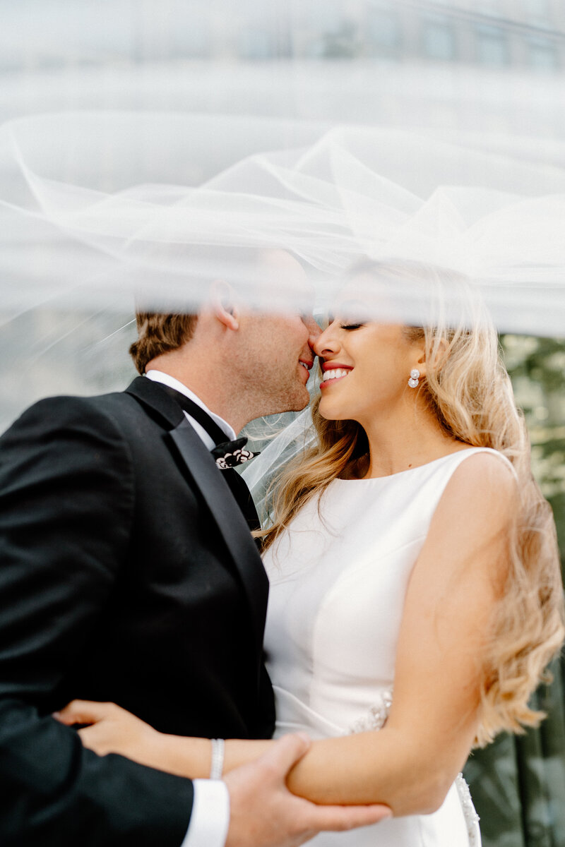 bride and groom under veil