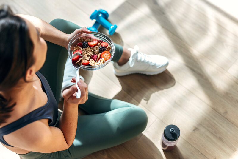 Woman eating a bowl of fruit