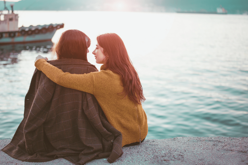 Lesbian couple sitting on edge of bay 19msa05