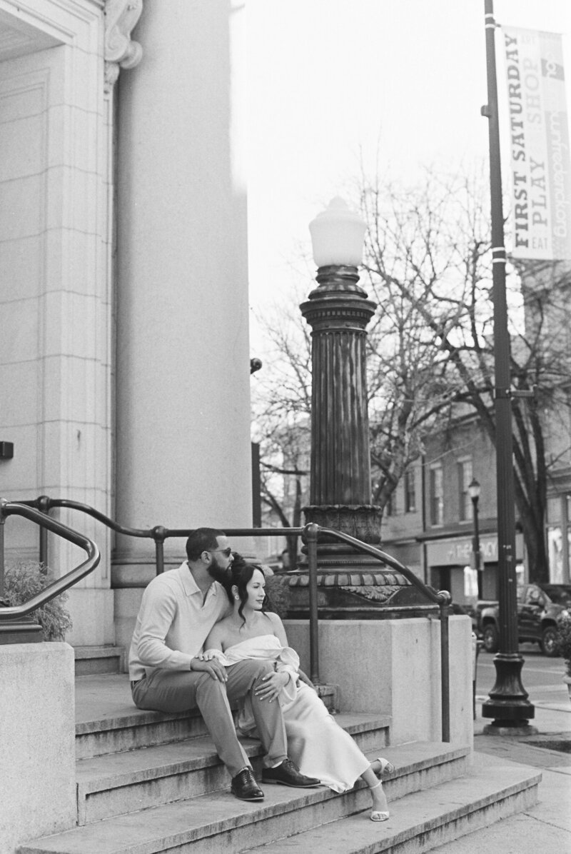 Couple sitting in front of pillars taken by wedding photographers in frederick md