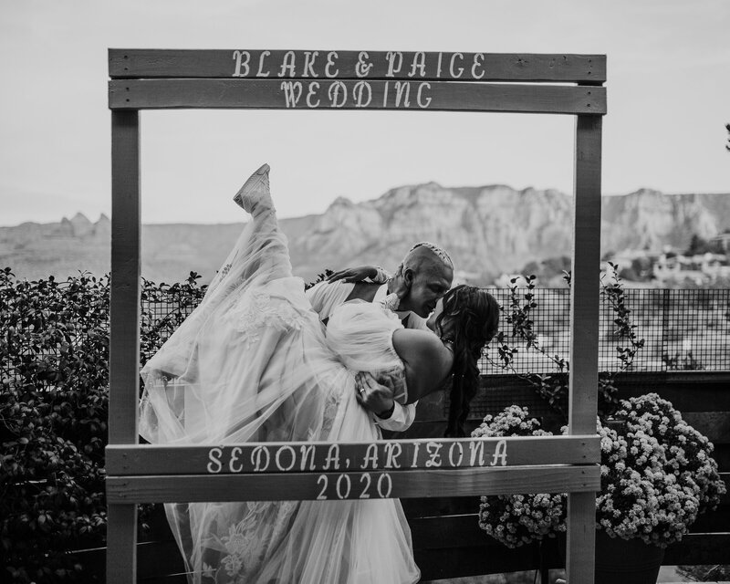 groom dipping bride at their photobooth in sedona