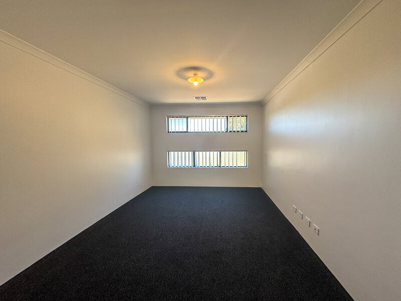 New theatre room with dark grey carpet, off white walls and two horizontal windows