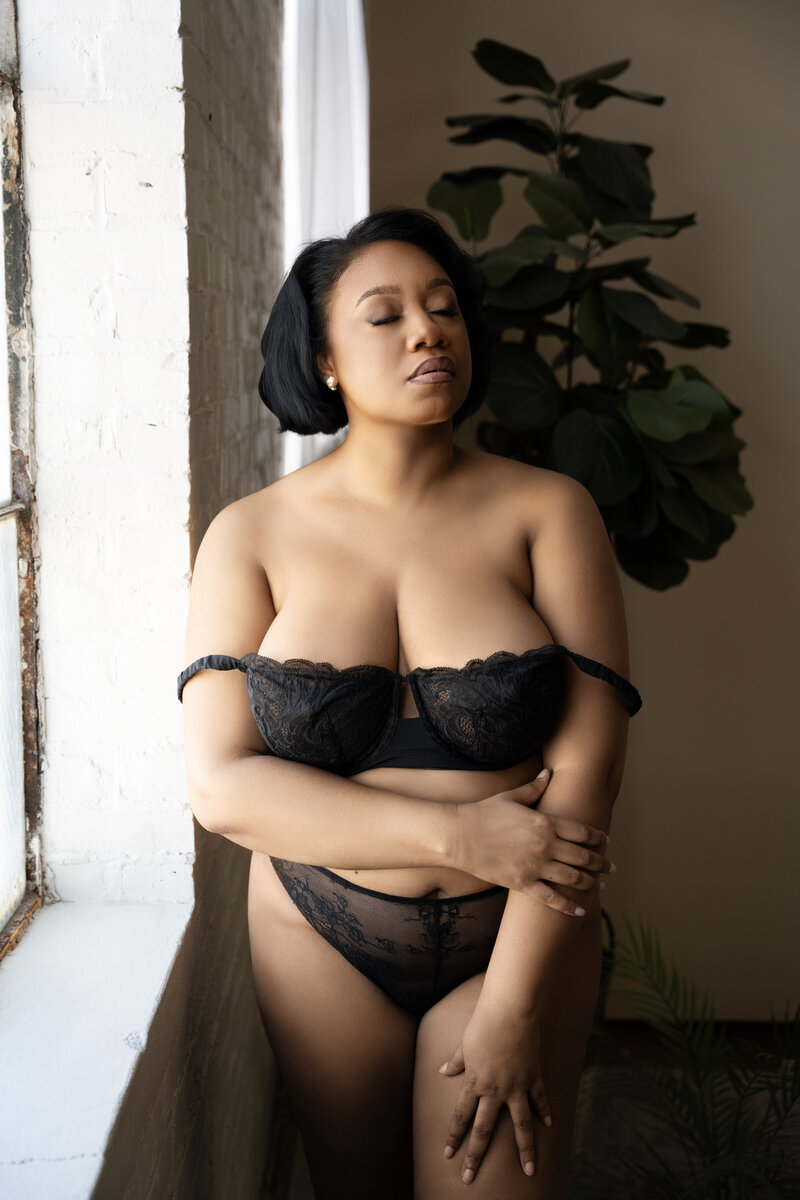 Nicole Griffin poses in black lingerie during a boudoir session in Maryland
