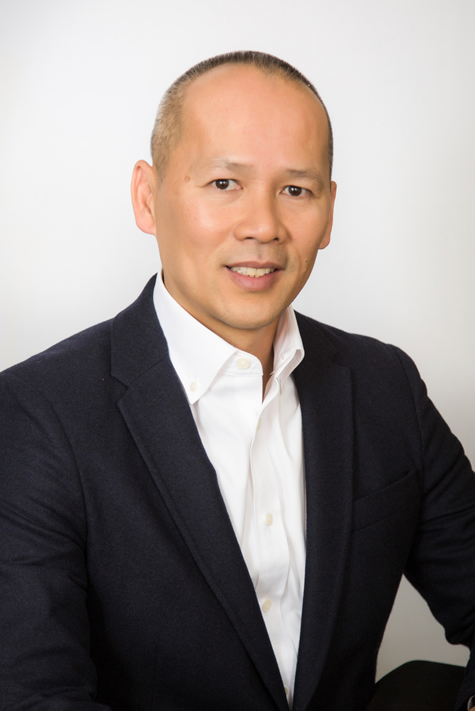 Headshot of Duc Le, a Film & Ink Entertainment Attorney with a closely shaved head, brown eyes, wearing a black suit jacket and white shirt.