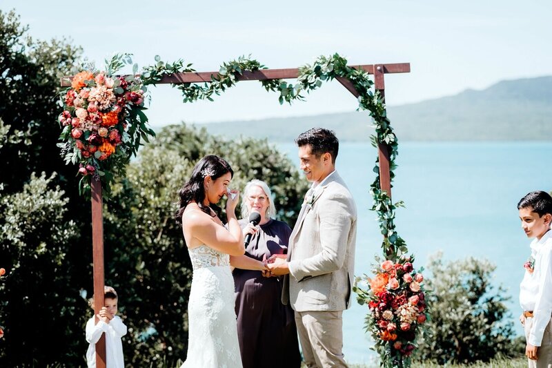 bride and groom stand at oceanfront wedding altar