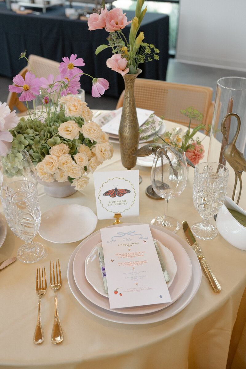 Colorful garden party wedding reception table with menu and table number with a handpainted watercolor butterfly and modern typography by Dear Margo Designs with flower arrangements by Lovelilly Floral