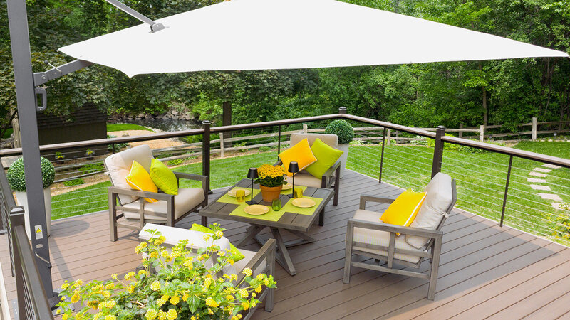 16-by-16 foot deck furnished with neutral furniture and bright yellow and lime green decorative accents. 