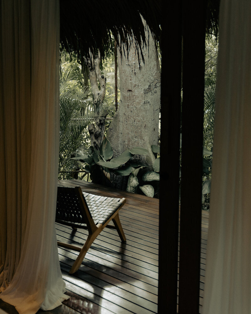 Private garden deck at Ronja Boutique Hotel, Uluwatu surrounded by tropical trees.