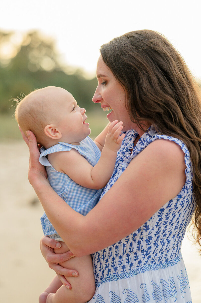 Mother holding her baby during a Williamsburg, Va family Yorktown beach photography session -captured in soft evening light by Jessica Barrett Photography, family photographer specializing in natural, connection-filled portraits and heirloom artwork