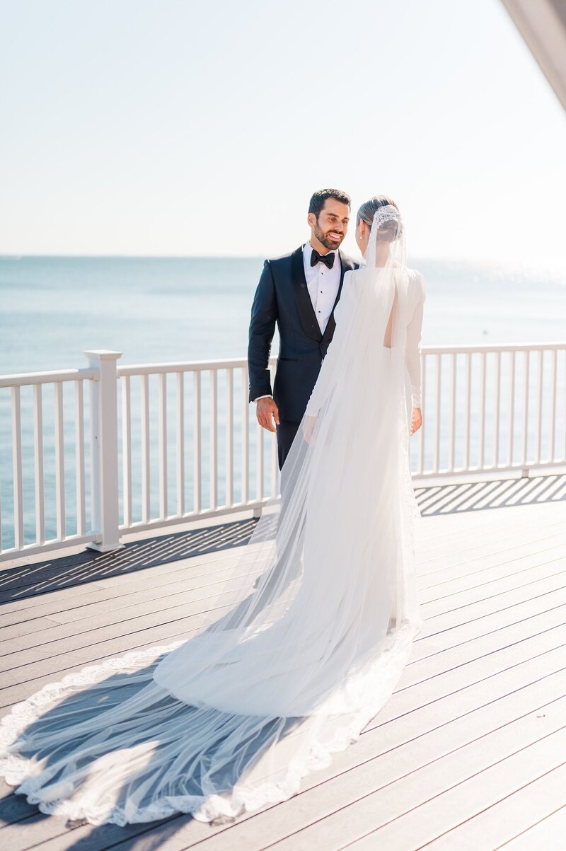 A bride walks out onto a deck as her groom sees her in her dress for the first time. 