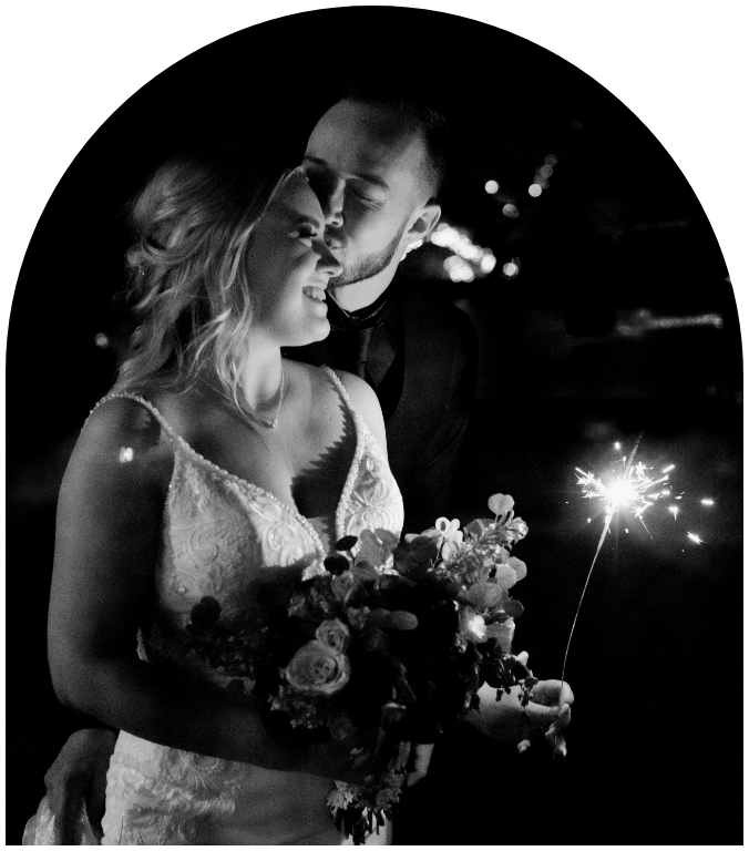 Bride holding a sparkler next to a groom