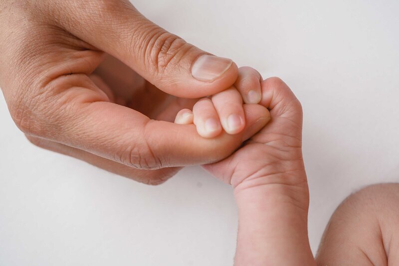 Newborn Toes in moms hands in dreamy ethereal studio lighting