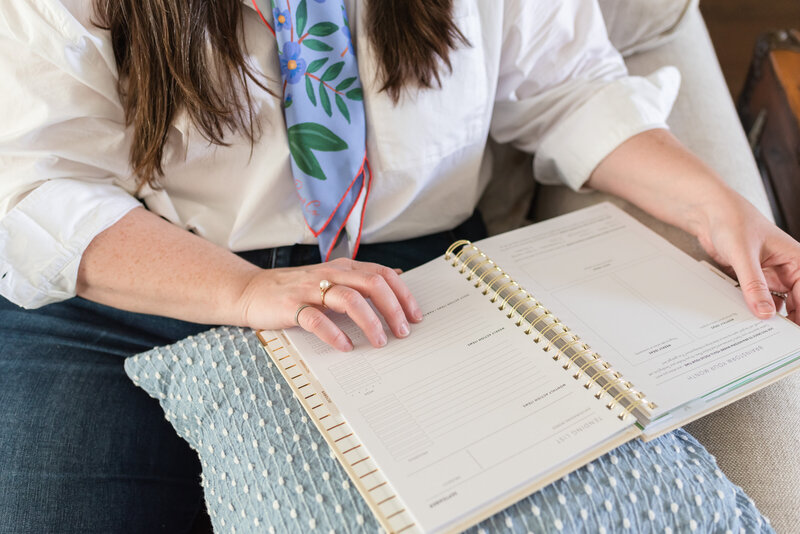 Lauren looks through her planner on her family room sofa