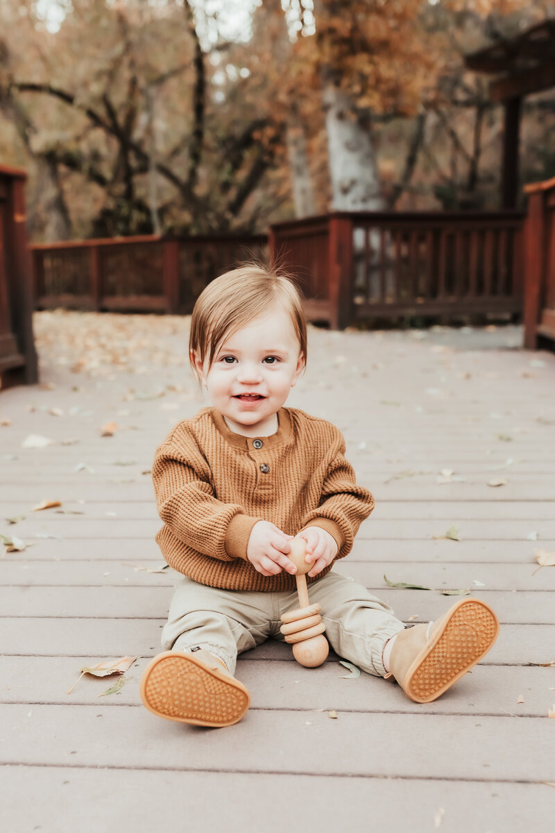 A toddler boy sitting on the walkway at Rancho Park.