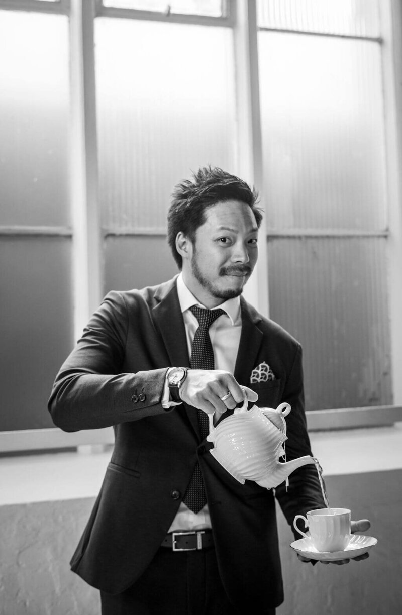 Chinese man holds teapot and teacup for portrait