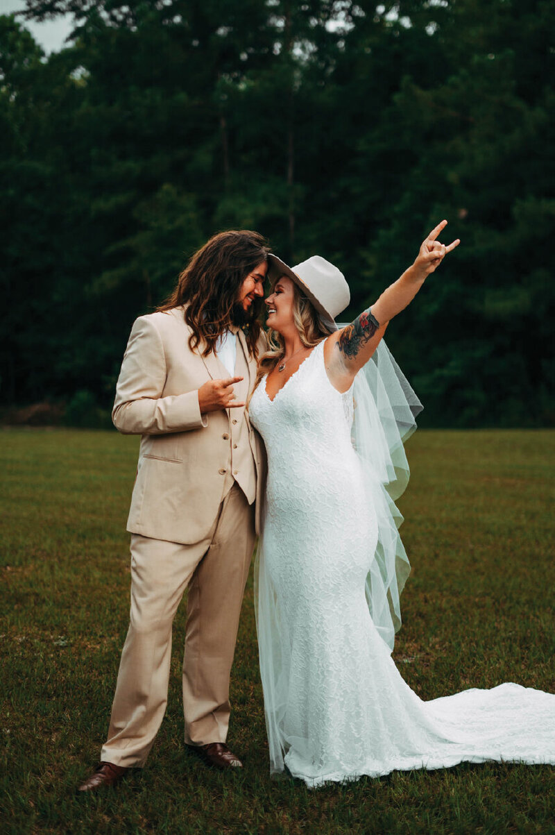Bride with husband with rock on hand sign