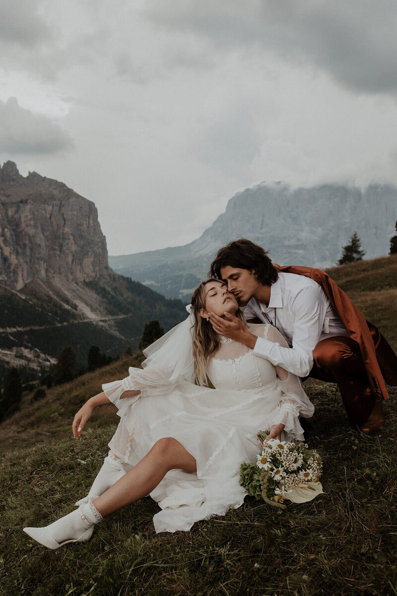 groom embracing bride on European hillside