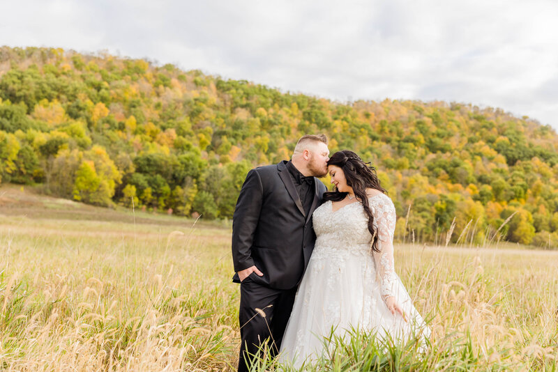 Bride and groom posing in front of beautiful Hill of Fall leaves at Chapers on the Horizon, Wisconsin
