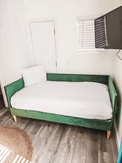 Cozy green daybed for additional sleeping space at Tropical House in Panama City Beach, perfect for families or friend groups.