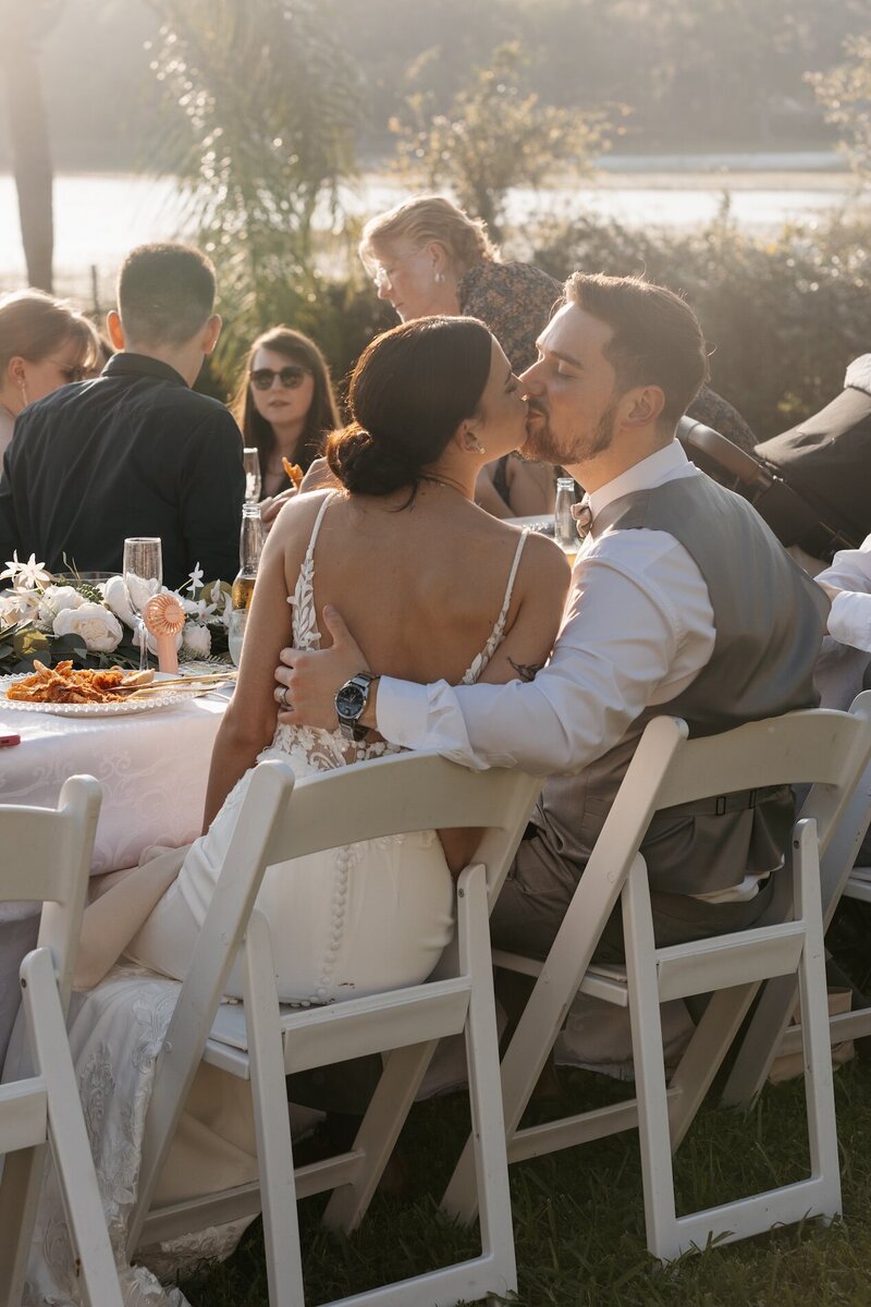 bride and groom kissing on wedding day during reception