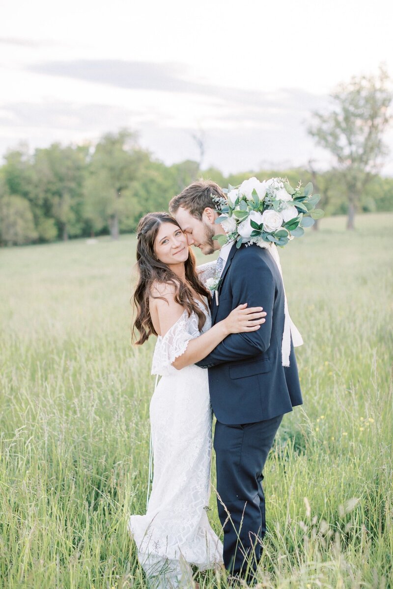 Bride and groom in a field during sunset photos at their Charlottesville venue. Taken by Rachel Jordan Photography.