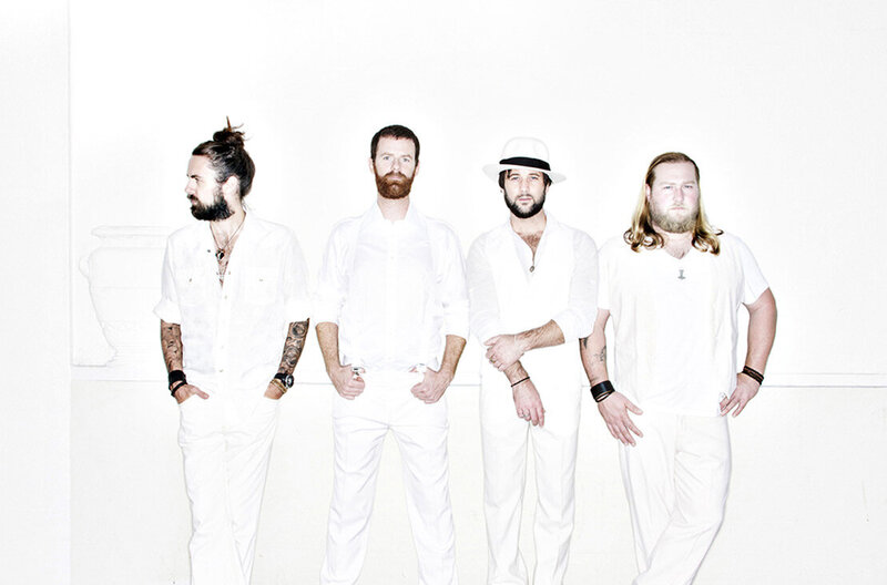 Band portrait The Matinee four members dressed in white standing against white wall