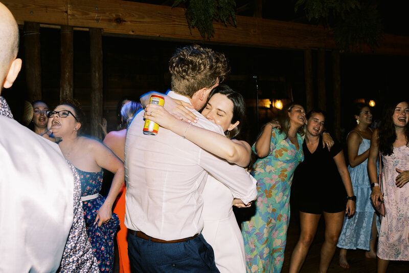 The bride and groom embrace on the dance floor during their reception at Paint Rock Farm a wedding venue in the hills of North Carolina, by destination photographer My Sun and Stars Co.