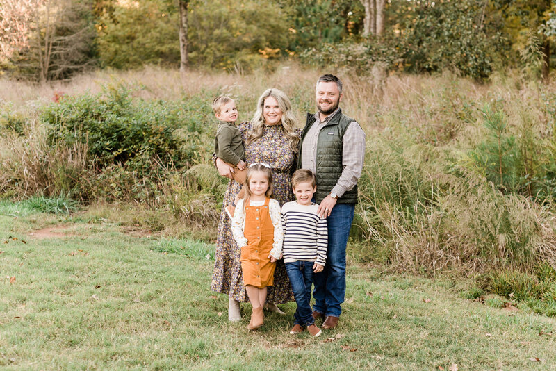 Family of 5 smiling for a portrait during their fall mini session with Raleigh family photographers A.J. Dunlap Photography.