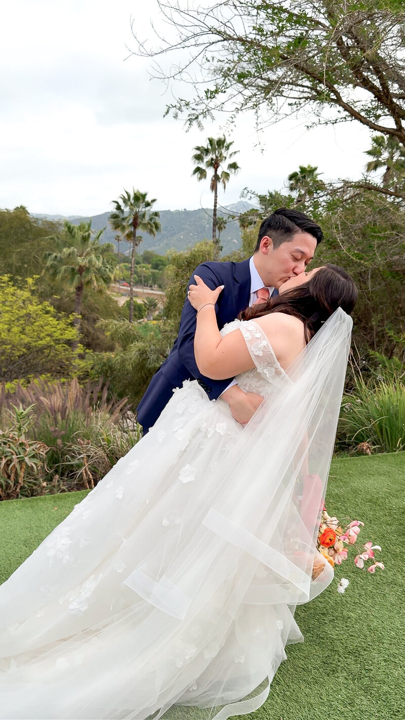 Bride and groom kissing and dipping during portraits on their wedding day at San Diego Safari Park San Diego Zoo Safari Park.