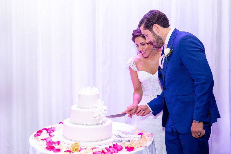 Bride and groom cutting their wedding cake at Briza on the Bay in Miami, photographed during their wedding day photo timeline with a First Look.