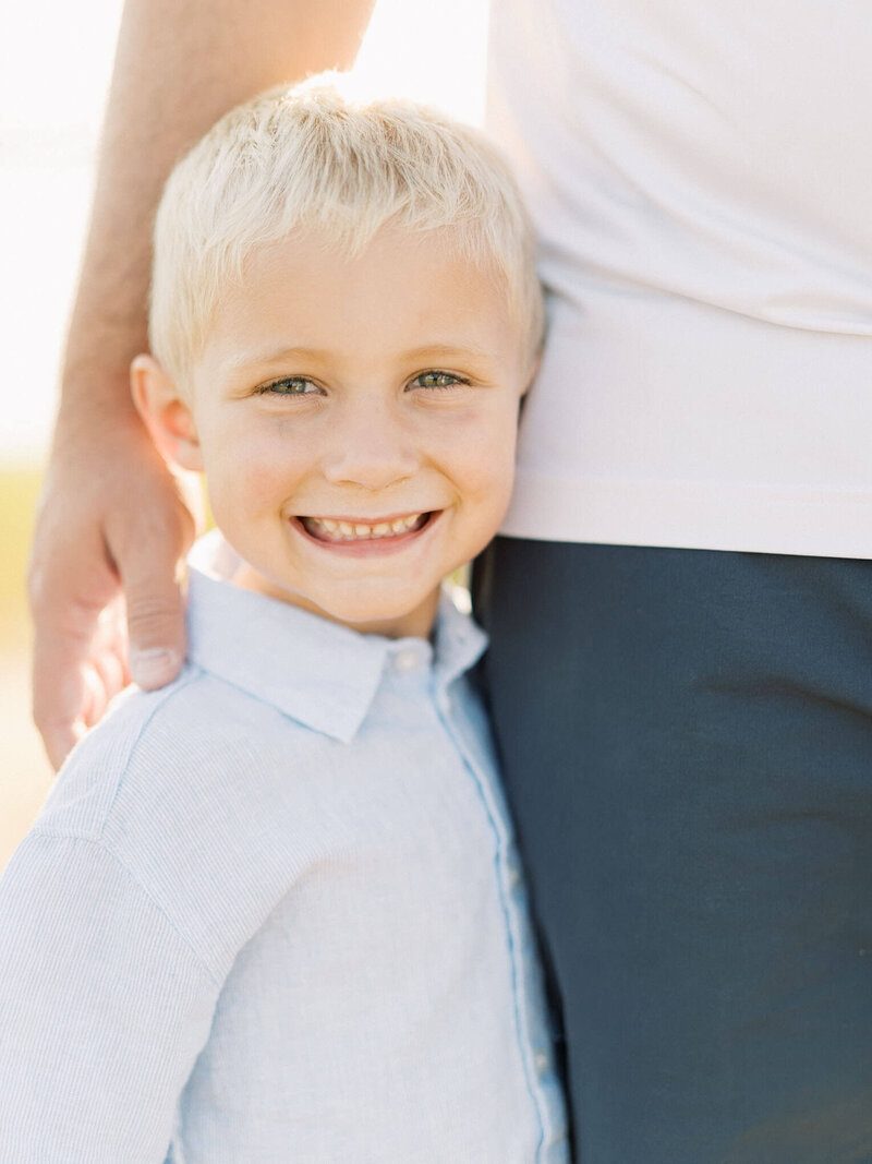 little boy smiles during family session By Carrie Pellerin