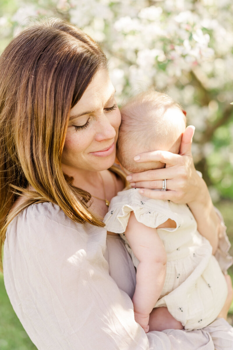 Mom cuddling baby at outdoor portrait session