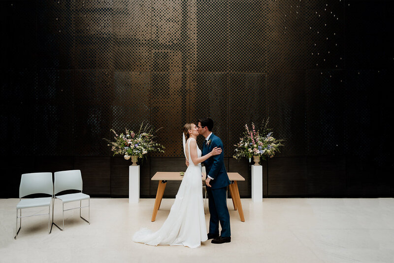 documentary photography of a couple kissing at north atrium hackney town hall wedding