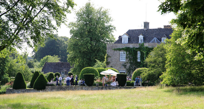 Garden party in the summer time in the countryside with green grass, trees and a stately home