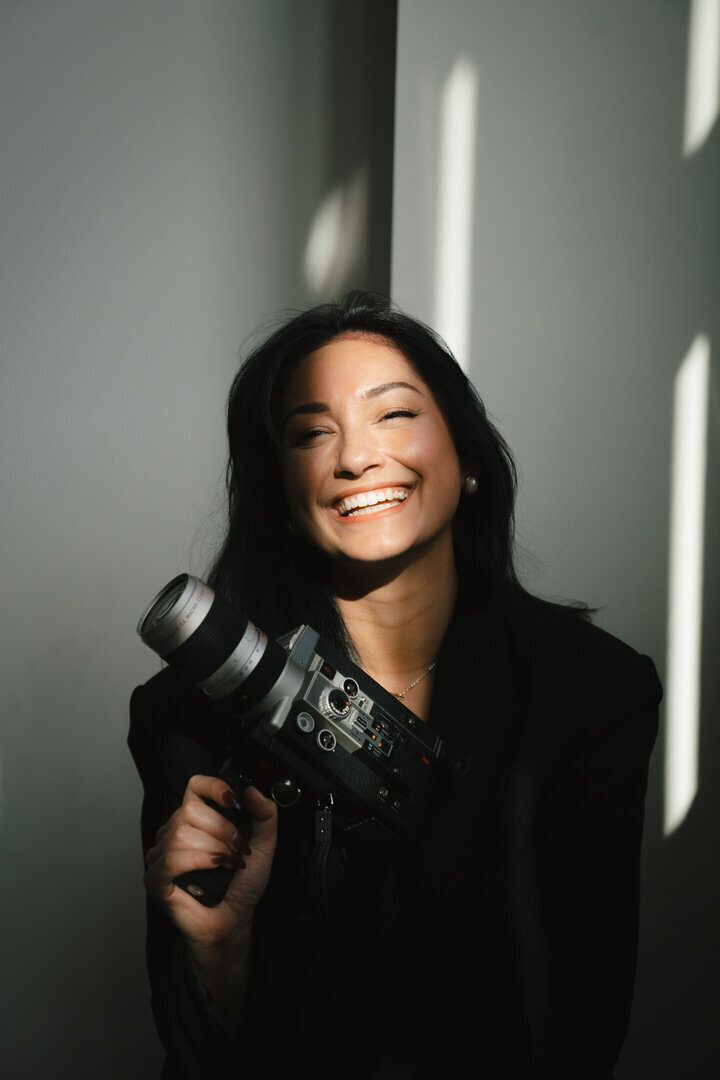 girl smiling holding super 8 camera