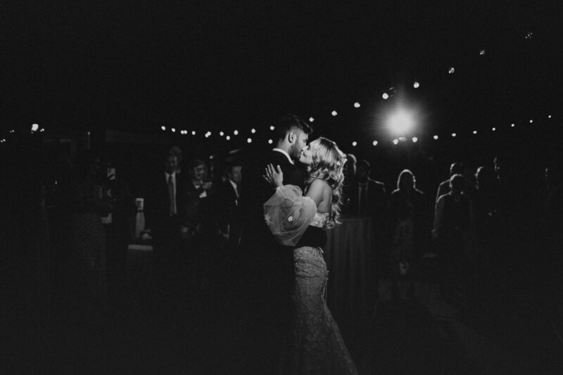 couple kissing at reception black and white photo